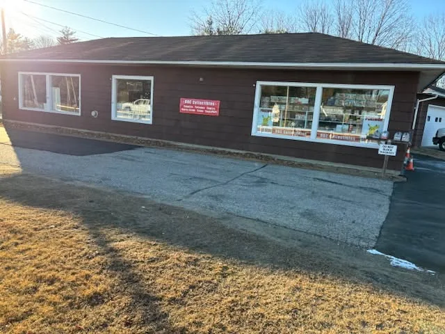 Roc Collectibles storefront: brown shingled building with a red sign over the door and Pokémon decals in the windows